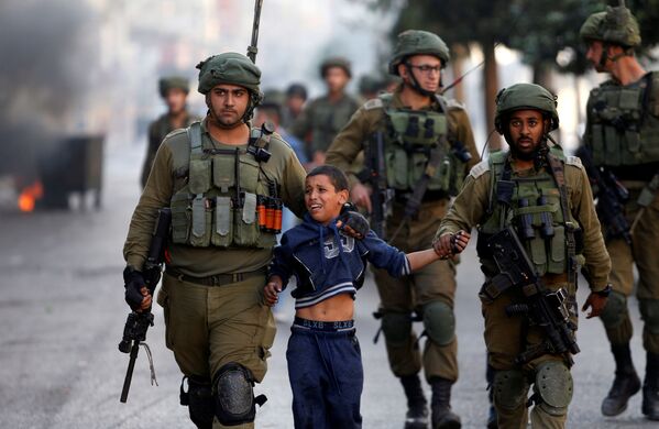 Израильские солдаты задержали палестинского мальчика во время столкновений в Хевроне