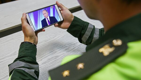 Военнослужащий смотрит трансляцию выступления президента РФ Владимира Путина на заседании клуба Валдай. 19 октября 2017