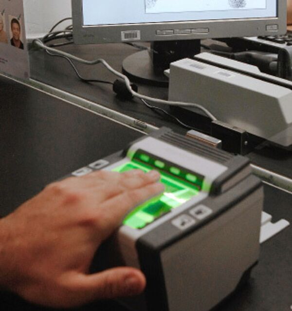 Сбор биометрических данных при помощи специального устройства, сканирующего отпечатки пальцев, в посольстве Великобритании в Москве.