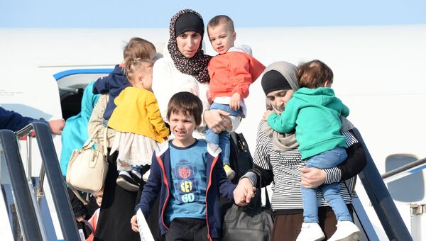 Дети и родители, возвращенные из Сирии, выходят из самолета в аэропорту Грозного. 21 октября 2017