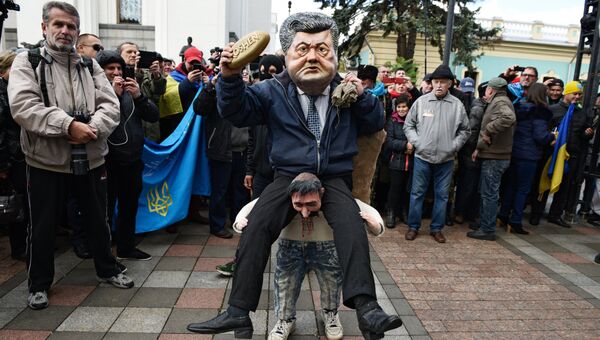 Ряженый в костюме президента Украины Петра Порошенко, который сидит на плечах у украинского казака, во время вече у здания Верховной рады в Киеве