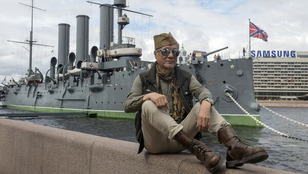 Мужчина на Петроградской набережной возле музея Крейсер Аврора в Санкт-Петербурге