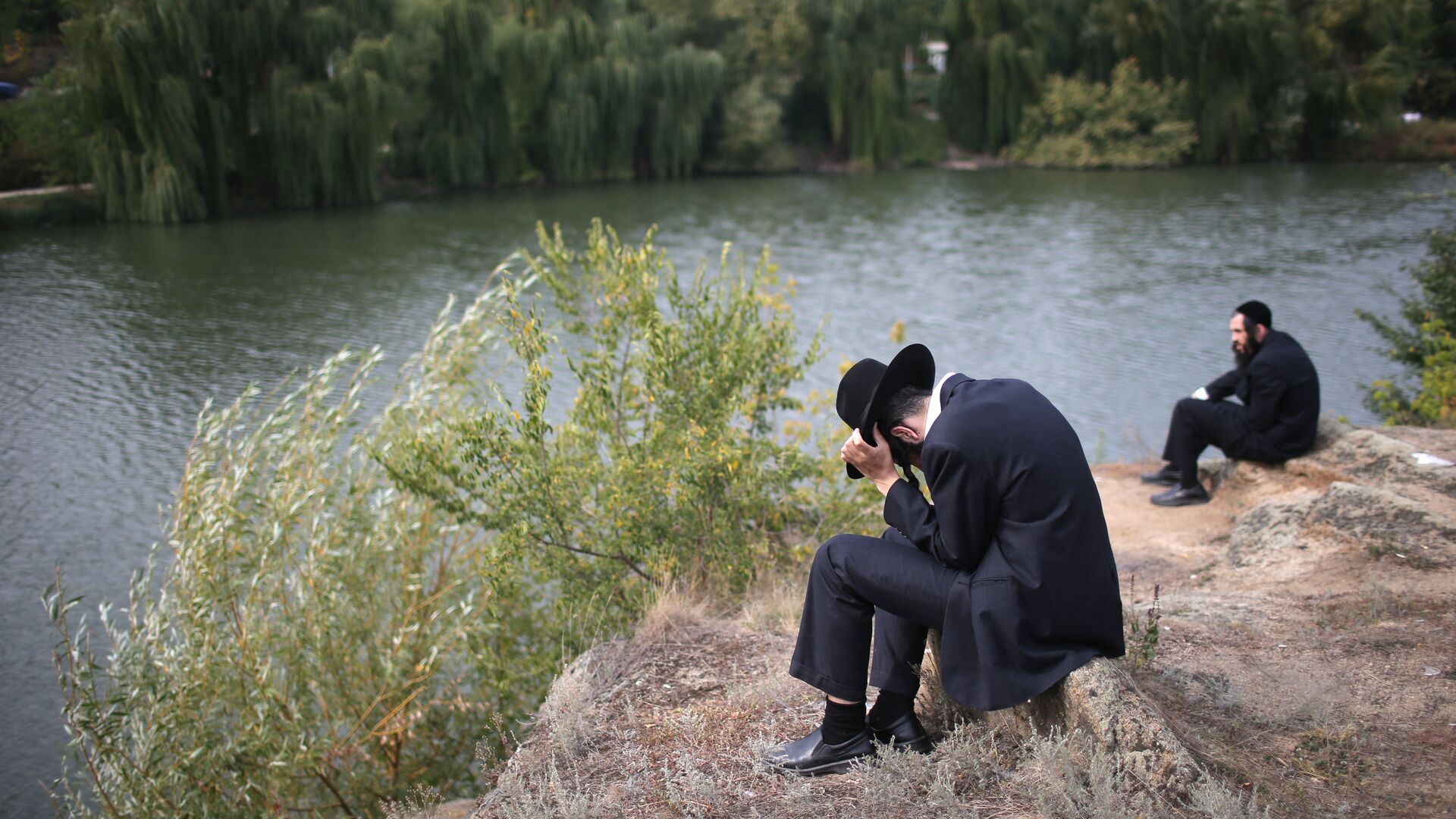 Паломник сидит на берегу реки в канун еврейского нового года на Украине - РИА Новости, 1920, 07.09.2021