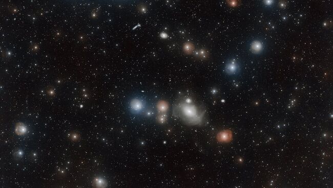 Галактика NGC 1317, лицо бога, и ее ближайшие соседи по скоплению галактик в созвездии Печи. Архивное фото