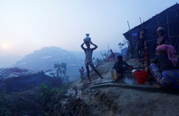 Беженцы рохинджа набирают питьевую воду рядом с городом Кокс-Базар, Бангладеш