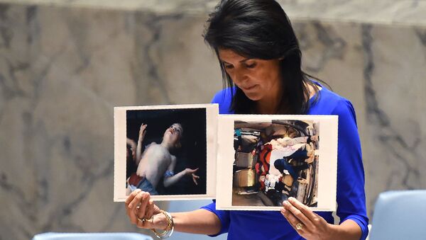 Постпред США при ООН Никки Хейли держит фотографии жертв предполагаемой химической атаки в Сирии