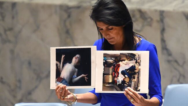 Постпред США при ООН Никки Хейли держит фотографии жертв предполагаемой химической атаки в Сирии