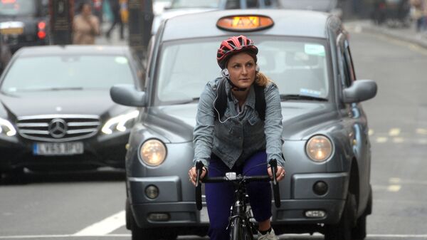 Девушка едет на велосипеде по улице Лондона