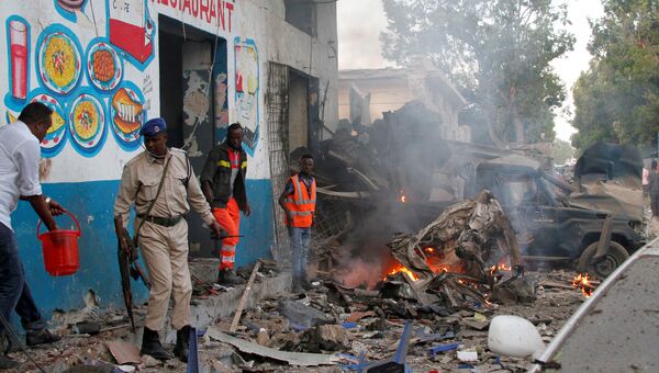 Офицеры безопасности на месте взрыва бомбы у ворот гостиницы возле президентского дворца в Могадишо, Сомали. 28 октября 2017