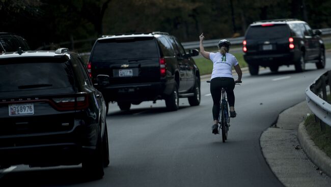 Велосипедиска рядом с кортежем президента США Дональда Трампа в Стерлинге, Виргиния. 28 октября 2017