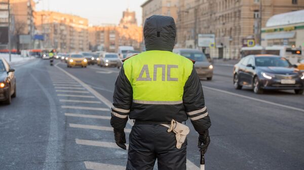 Сотрудник дорожно-патрульной службы дежурит на одной из улиц Москвы