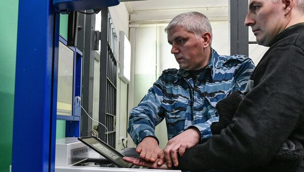 Сотрудник ФСИН России сканирует ладонь заключенного на многофункциональной дактилоскопической станции ПАПИЛОН МДС 45c в Следственном изоляторе № 2. 31 октября 2017