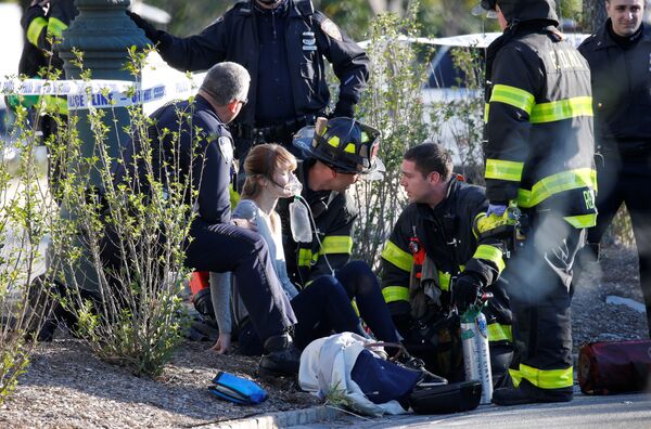 Спасатели оказывают помощь пострадавшей в результате наезда грузовика на велосипедистов в Нью-Йорке. 31 октября 2017