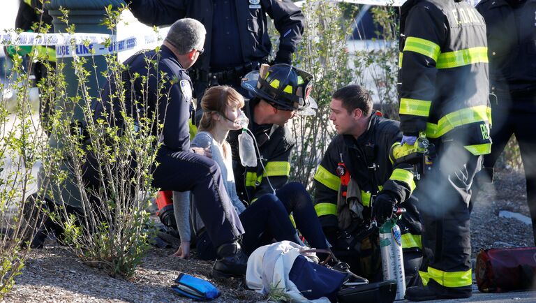 Спасатели оказывают помощь пострадавшей в результате наезда грузовика на велосипедистов в Нью-Йорке. 31 октября 2017