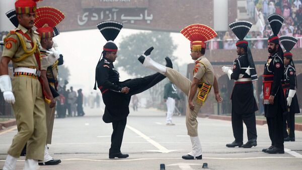 Пакистанские рейнджеры и бойцы войск пограничной безопасности Индии во время ежедневной церемонии спуска флагов в Вагахе. Архивное фото
