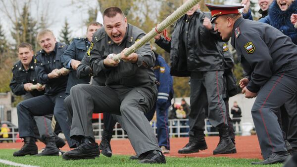 Сотрудники полиции участвуют в перетягивании каната во время спортивного праздника, посвященного Дню сотрудников органов внутренних дел в Великом Новгороде