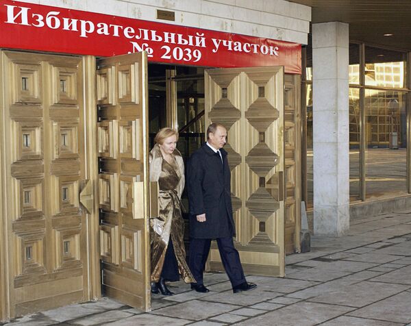 Президент РФ Владимир Путин и его супруга Людмила Путина после голосования на выборах президента Российской Федерации выходят из избирательного участка №2039