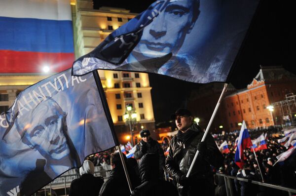 Участники санкционированного митинга в поддержку кандидата в президента РФ Владимира Путина на Манежной площади