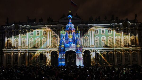 Зрители смотрят мультимедийный спектакль на фестивале света на Дворцовой площади в Санкт-Петербурге. Архивное фото