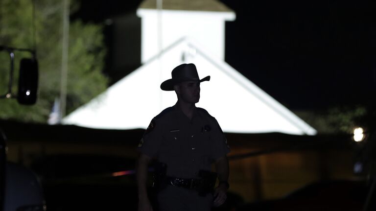 Сотрудник правоохранительных органов США на месте стрельбы у церкви в Сатерленд Спрингс в Техасе, США. 5 ноября 2017