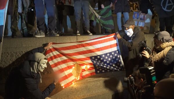 Активисты Anonymous сожгли флаг США на Марше миллиона масок в Лондоне