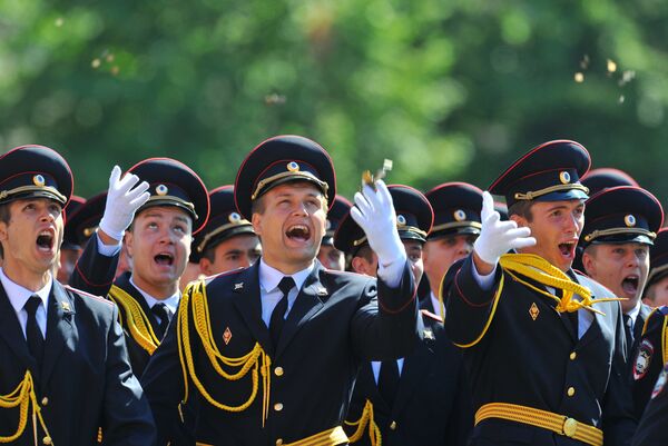 Выпускники Московского университета МВД России бросают в воздух монет на торжественной церемонии вручения дипломов