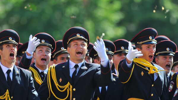 Выпускники Московского университета МВД России бросают в воздух монет на торжественной церемонии вручения дипломов
