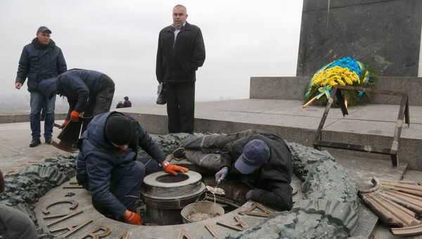 Рабочие удаляют цемент с оскверненного Вечного огня в Киеве. 7 ноября 2017