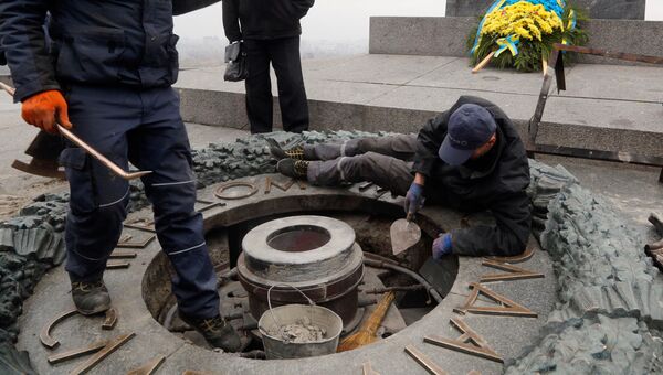 Рабочие удаляют цемент с оскверненного Вечного огня в Киеве. 7 ноября 2017