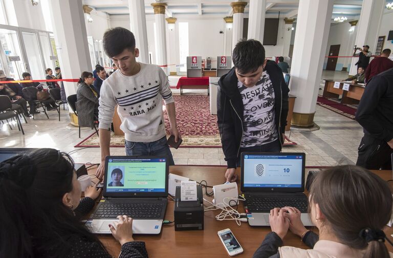 Избиратели проходят процедуру подтверждения личности с помощью сканирования отпечатка пальца на избирательном участке в Бишкеке, перед тем как проголосовать на выборах президента Киргизии Избиратели проходят процедуру подтверждения личности с помощью сканирования отпечатка пальца на избирательном участке в Бишкеке, перед тем как проголосовать на выборах президента Киргизии