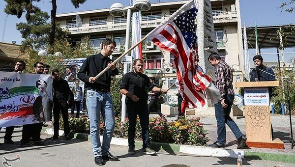 Студенты жгут флаг США во время протестов в Тегеране, Иран