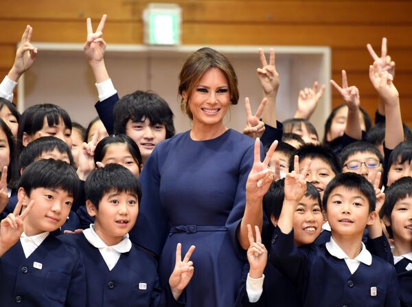 Меланья Трамп позирует с учениками во время посещения начальной школы в Токио. 6 ноября 2017