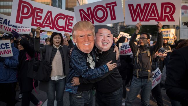 Демонстранты в масках, изображающих Дональда Трампа и Ким Чен Ына. Архивное фото