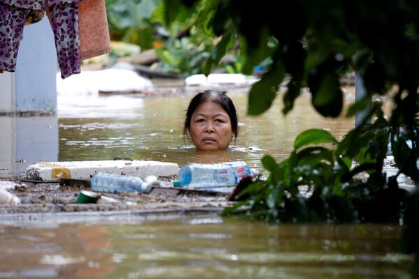 Женщина на затопленной улице Хойана после тайфуна Дамри