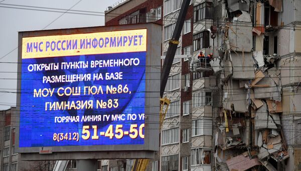 Информационное сообщение служб МЧС РФ на рекламном экране неподалеку от частично обрушившегося жилого панельного дома на Удмуртской улице в Ижевске. 10 ноября 2017
