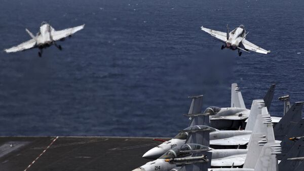 Истребители США F/A-18 взлетают с палубы авианосца США USS George H.W. Bush в Персидском заливе