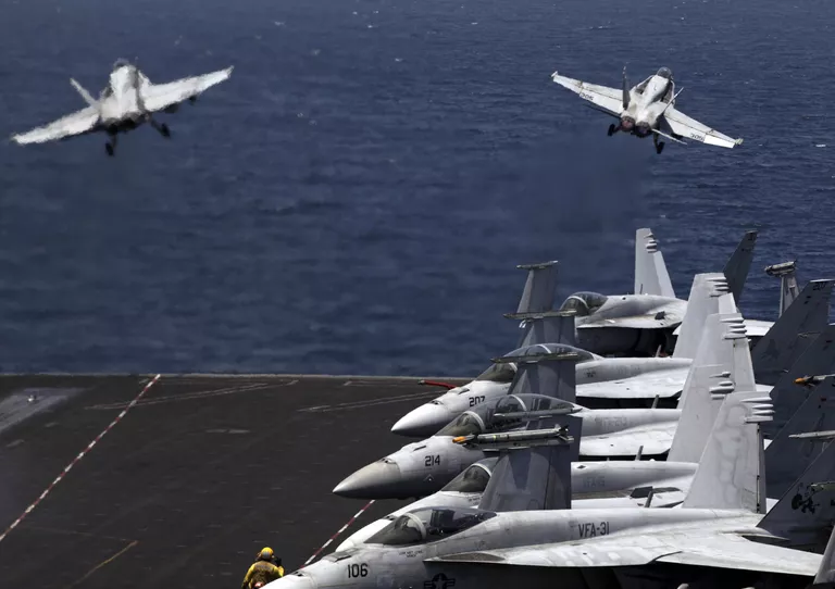 Истребители США F / A-18 вылетают с летной палубы авианосца США USS George H.W. Bush в Персидском заливе Истребители США F / A-18 вылетают с летной палубы авианосца США USS George H.W. Bush в Персидском заливе