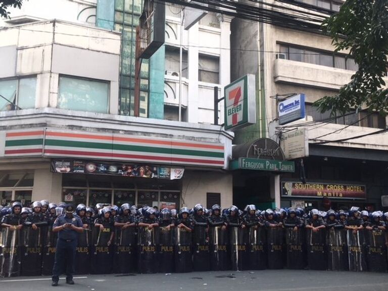 Сотрудники полиции во время акции протеста против визита президента США Дональда Трампа в Маниле, Филиппины. 12 ноября 2017