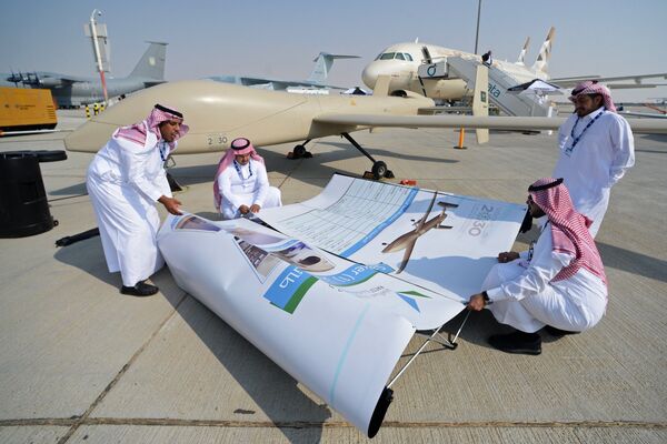 Участники монтируют баннер на Международной авиационно-космической выставке Dubai Airshow 2017