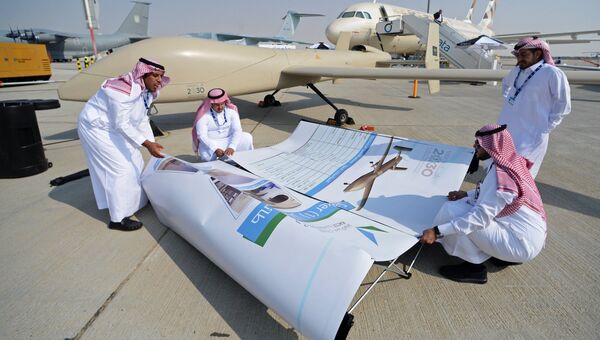 Участники монтируют баннер на Международной авиационно-космической выставке Dubai Airshow 2017