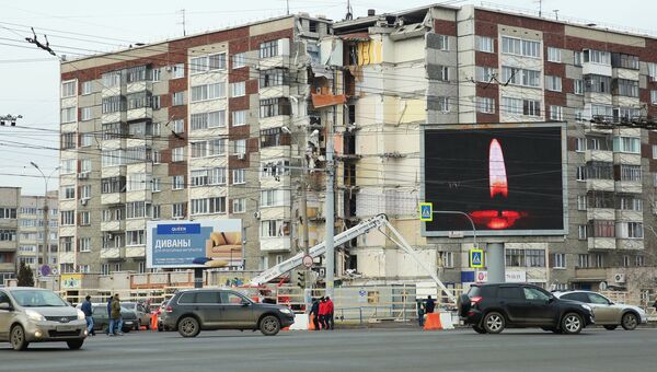 Щит с изображением свечи у жилого панельного дома по Удмуртской улице в Ижевске. 13 ноября 2017