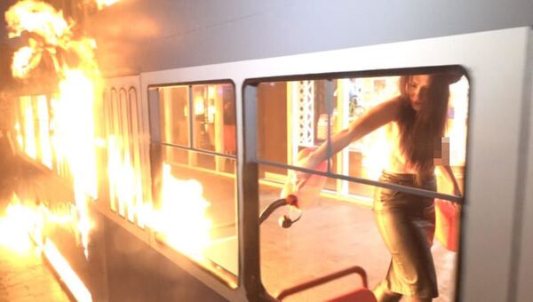 Активистка Femen подожгла игрушечный трамвайчик у магазина Roshen в Виннице