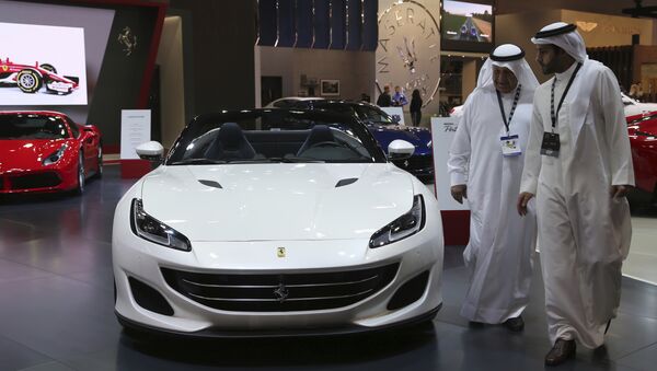 Посетители перед автомобилем Ferrari Portofino на Dubai Motor Show в ОАЭ. 14 ноября 2017