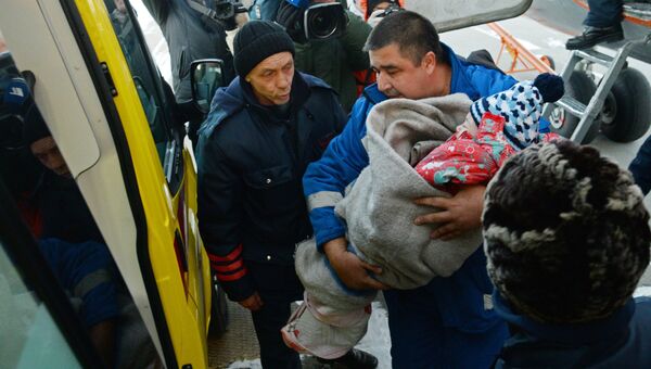 Сотрудник медицинской помощи переносит выжившую при крушении самолета L-410 девочку в автомобиль скорой помощи в Хабаровске. Архивное фото