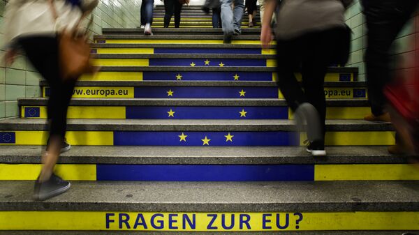 Пассажиры метро поднимаются по лестнице с изображением флага Евросоюза в Берлине