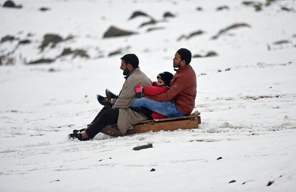 Люди катаются на санках после снегопада в Сонамаге, Кашмир