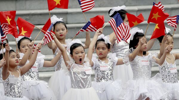 Дети машут флажками перед церемонией приветствия президента США Дональда Трампа в Президентском дворце в Ханое, Вьетнам