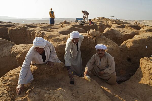 Рабочие в процессе зачистки раскопа в некрополе Дер Эль Банат в Фаюмском оазисе Египта