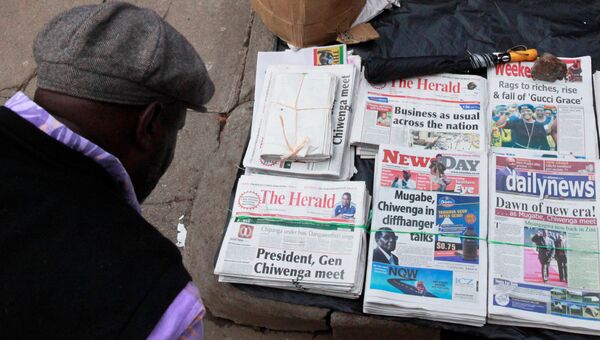 Мужчина читает заголовки газет в столице Зимбабве Хараре. 17 ноября 2017