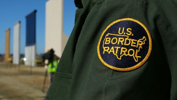 Сотрудник пограничной службы США рядом с прототипами пограничной стены недалеко от границы с Мексикой